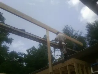 Carpenter setting a ridge beam over a new addition frame — Ice Dam Removal by Roofing Brothers in Beaverdam