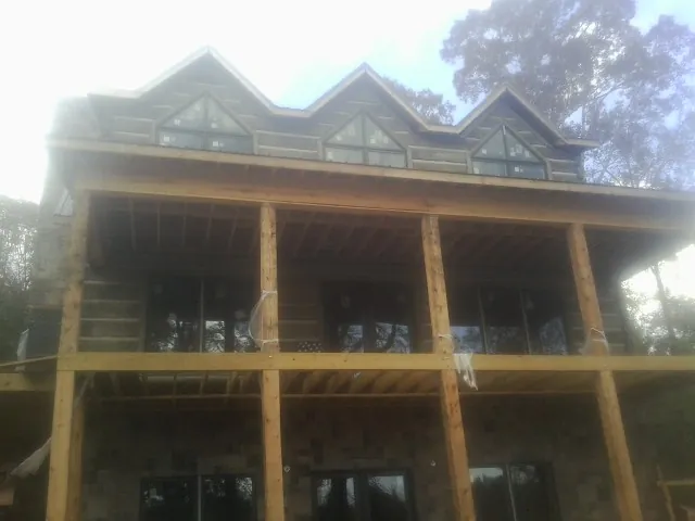 Dormers and porch framing on a large log home under construction — Roof Coating work by our crew in Beaverdam