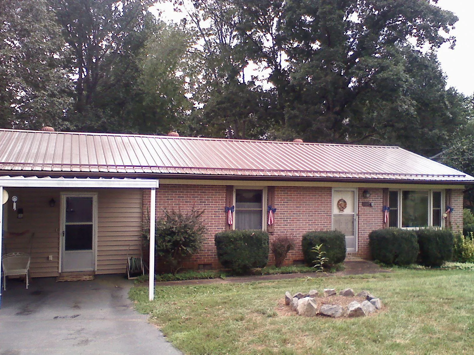 Bronze metal roof and carport on a brick ranch home — Roof Repair work by our crew in Beaverdam